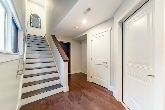 stairs with wood finished floors, visible vents, and baseboards