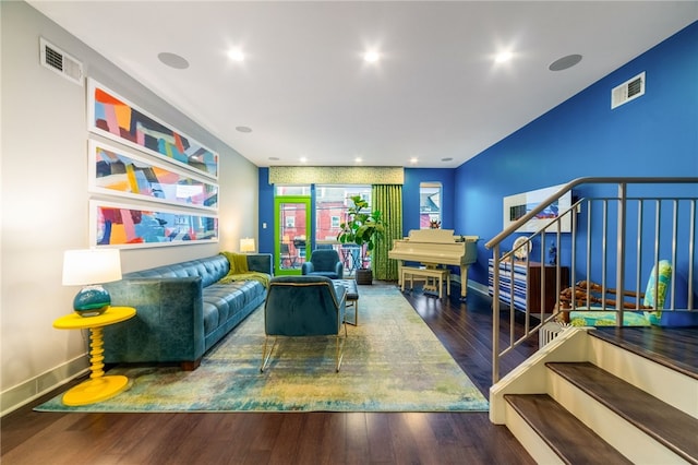 living room featuring visible vents, stairway, baseboards, and wood finished floors