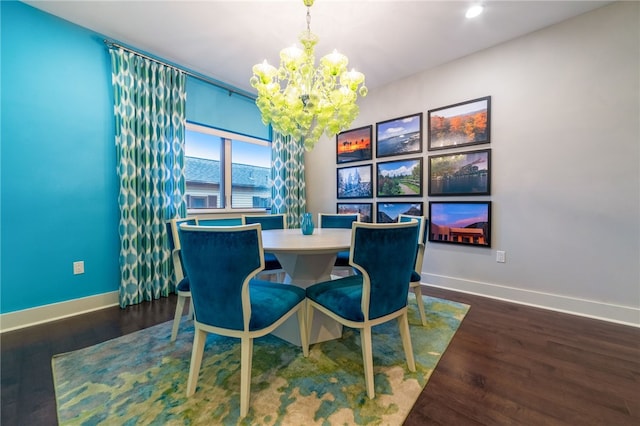 dining area with baseboards, wood finished floors, and a notable chandelier