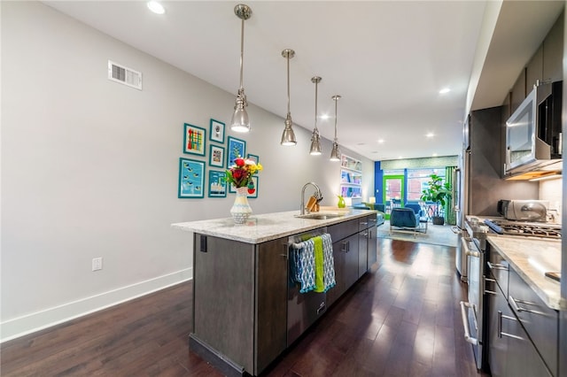 kitchen with visible vents, open floor plan, dark wood-type flooring, stainless steel appliances, and a sink