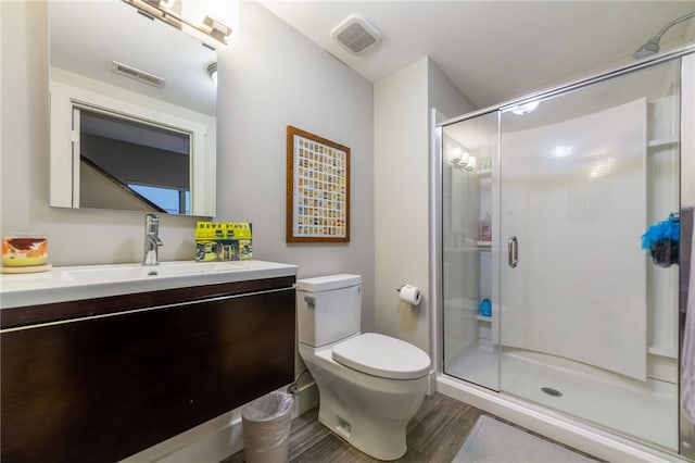 full bath featuring visible vents, toilet, wood finished floors, vanity, and a shower stall