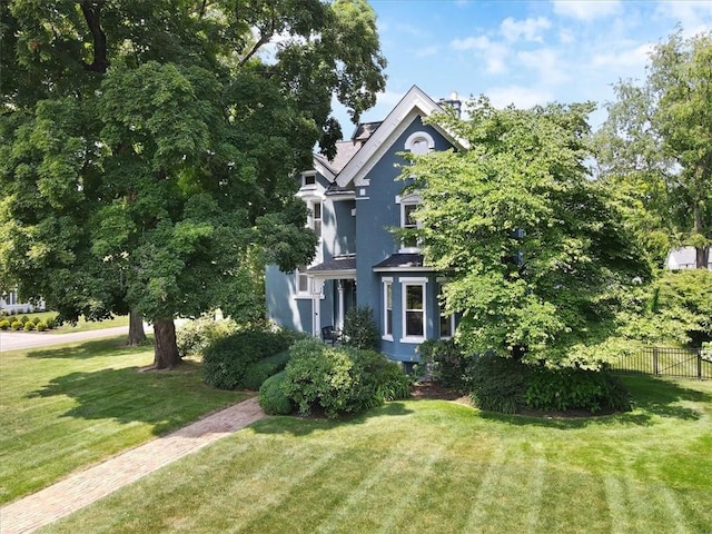 view of side of home featuring stucco siding, fence, and a yard