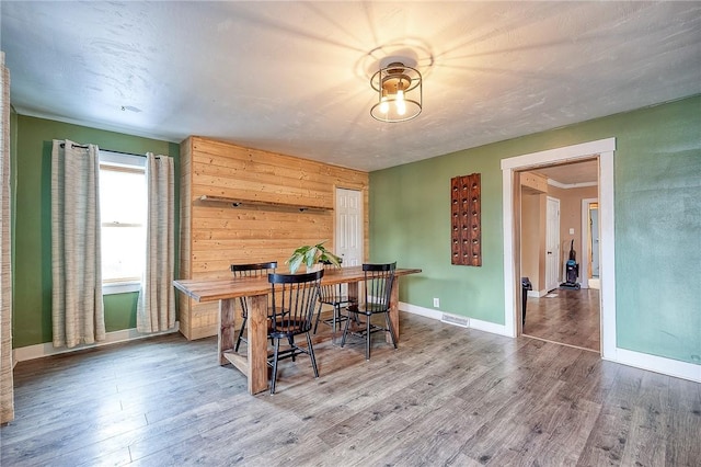 dining space featuring visible vents, baseboards, and wood finished floors