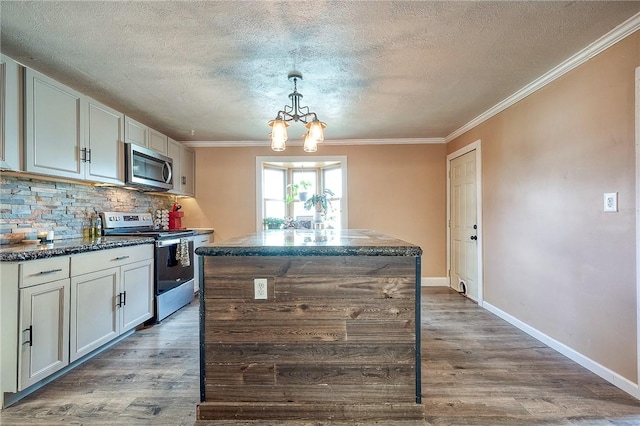 kitchen with a center island, tasteful backsplash, appliances with stainless steel finishes, ornamental molding, and wood finished floors