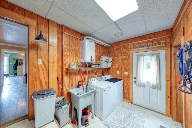 washroom featuring laundry area, wooden walls, and washer and clothes dryer