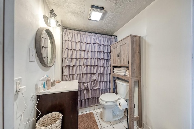 full bath featuring toilet, vanity, a textured ceiling, and tile patterned floors