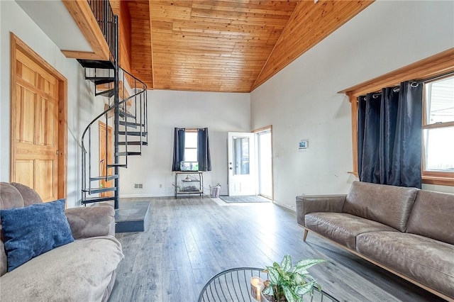 living area with baseboards, wood ceiling, stairway, hardwood / wood-style floors, and high vaulted ceiling