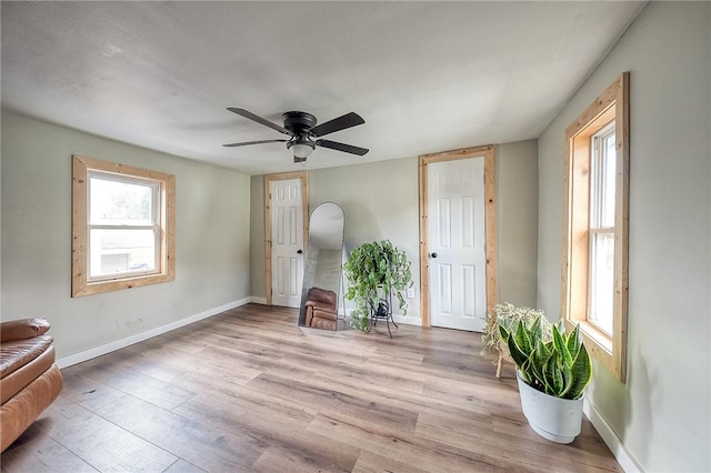 interior space with light wood-style floors, baseboards, and a ceiling fan