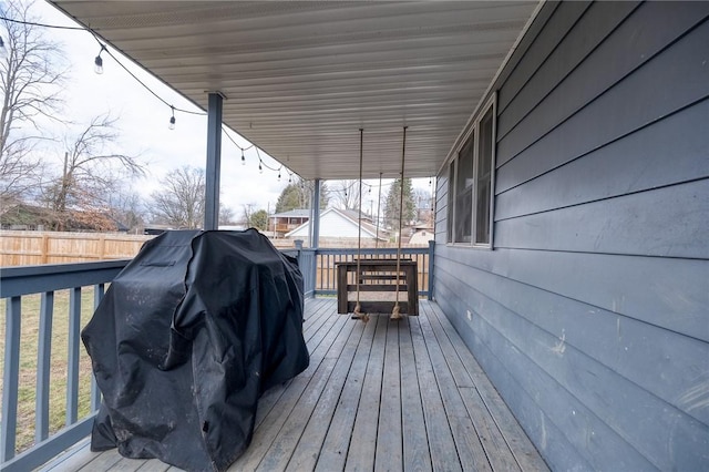 wooden deck featuring a grill and fence