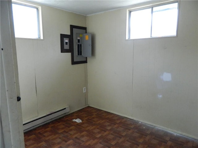 empty room with electric panel, a healthy amount of sunlight, and a baseboard radiator