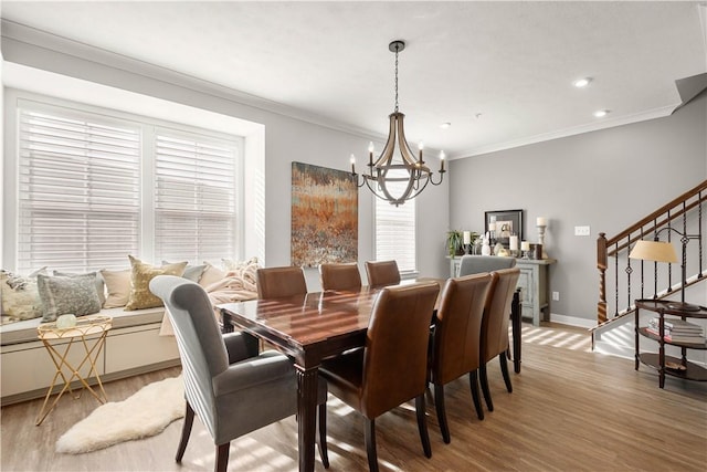 dining space with baseboards, stairs, ornamental molding, light wood-type flooring, and an inviting chandelier