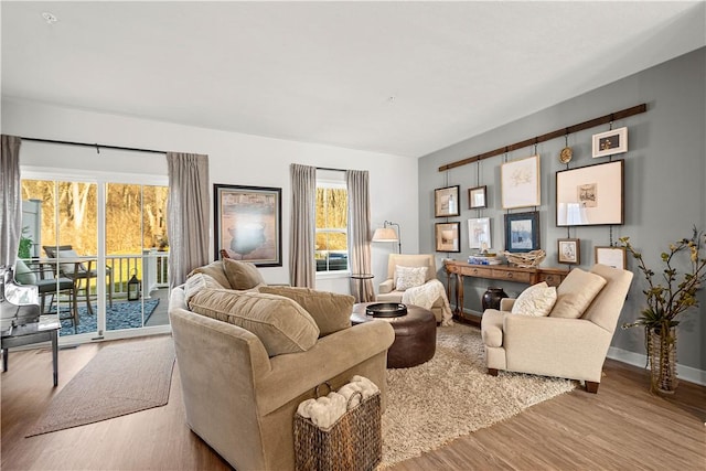 living area with baseboards and wood finished floors