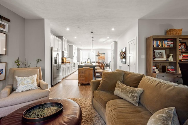 living area with light wood-type flooring and recessed lighting