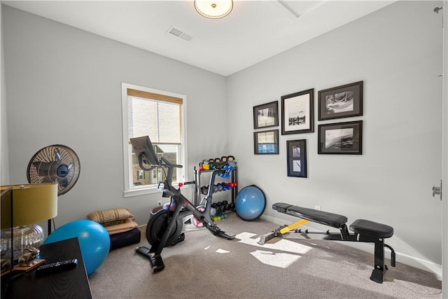 workout area featuring baseboards, visible vents, and carpet flooring