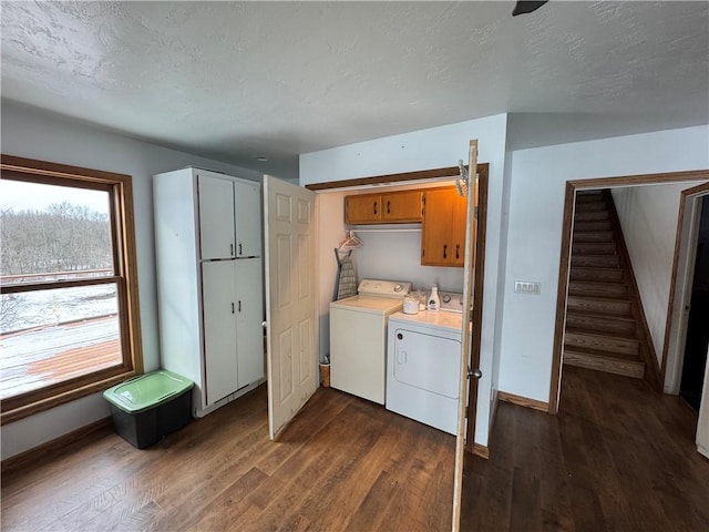 washroom with cabinet space, a textured ceiling, independent washer and dryer, and dark wood-style floors