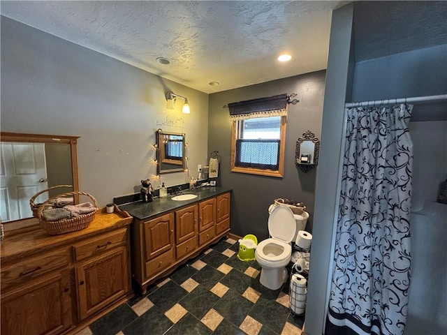 bathroom with a textured ceiling, toilet, vanity, and a shower with curtain