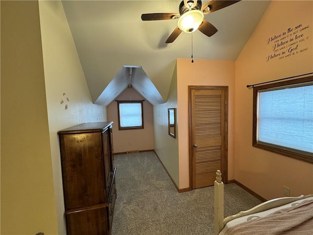 bedroom featuring a ceiling fan, carpet, baseboards, visible vents, and lofted ceiling