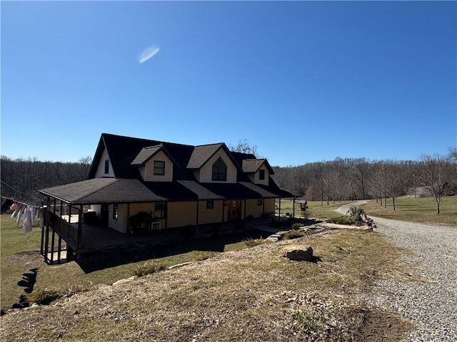 view of side of property with a porch and a yard