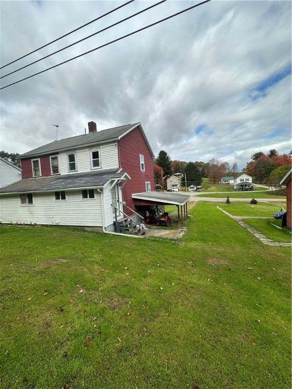 back of property featuring a lawn and a chimney