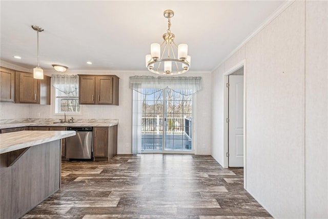 kitchen featuring dishwasher, dark wood-style floors, crown molding, a chandelier, and a sink