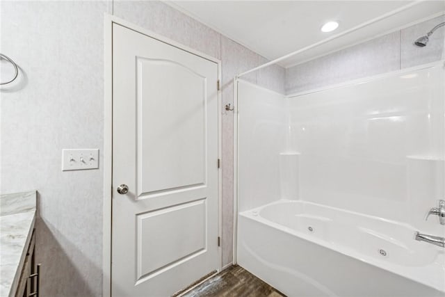 bathroom featuring shower / washtub combination, wood finished floors, and vanity