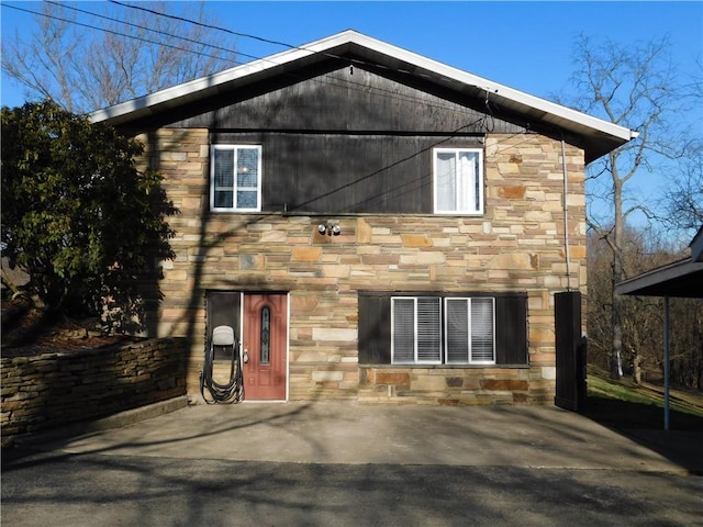 rear view of property with stone siding