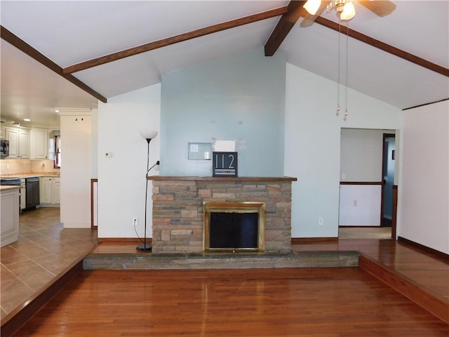 unfurnished living room featuring beamed ceiling, a fireplace, wood finished floors, and baseboards