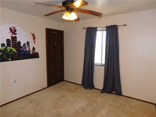 unfurnished room featuring ceiling fan, baseboards, and light colored carpet