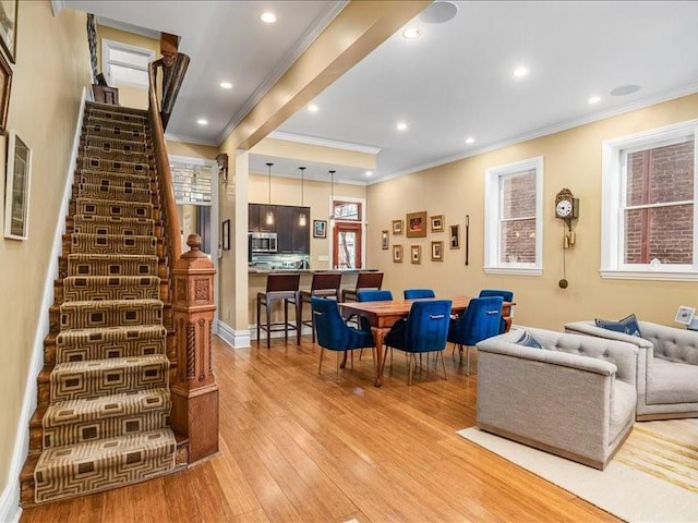 living room featuring ornamental molding, light wood-type flooring, stairway, and recessed lighting