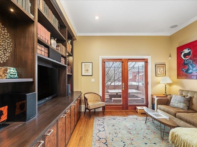 living area featuring ornamental molding and light wood-type flooring