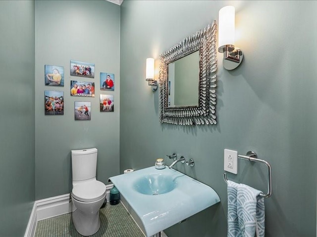 bathroom with toilet, baseboards, a sink, and tile patterned floors