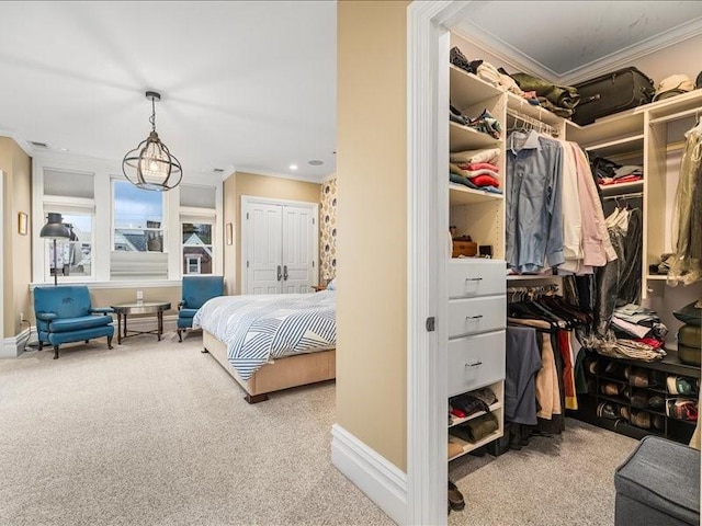 carpeted bedroom with a closet, crown molding, and baseboards