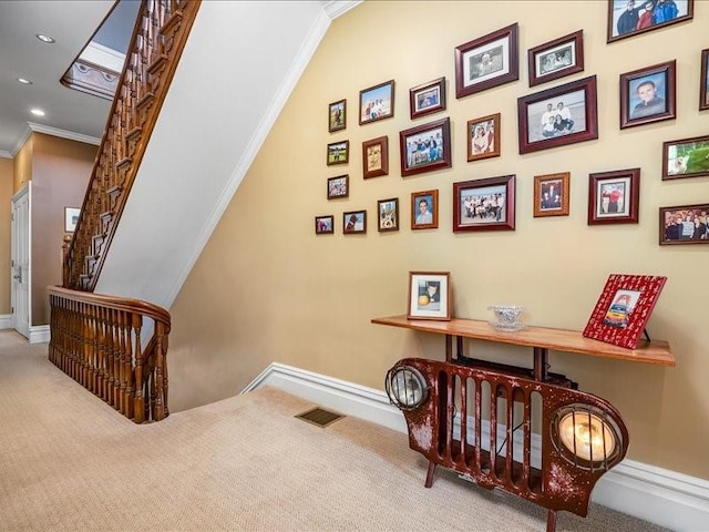 stairs featuring ornamental molding, visible vents, and carpet floors