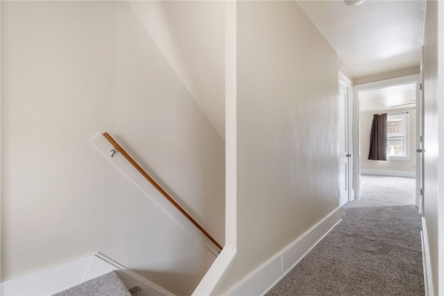 hall with carpet, an upstairs landing, and baseboards