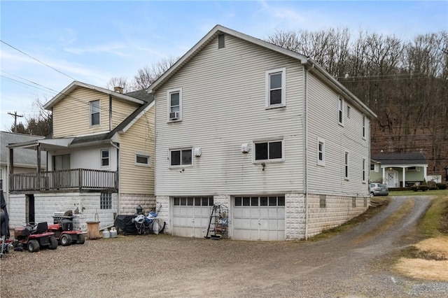 view of home's exterior with a garage, cooling unit, and driveway