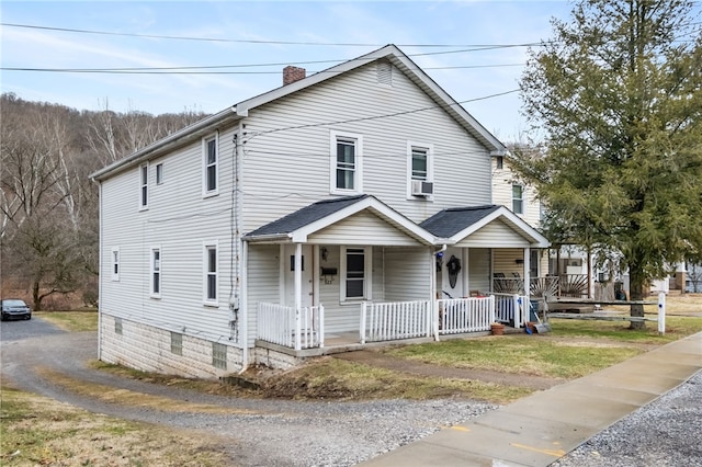 view of front of home with covered porch and a chimney