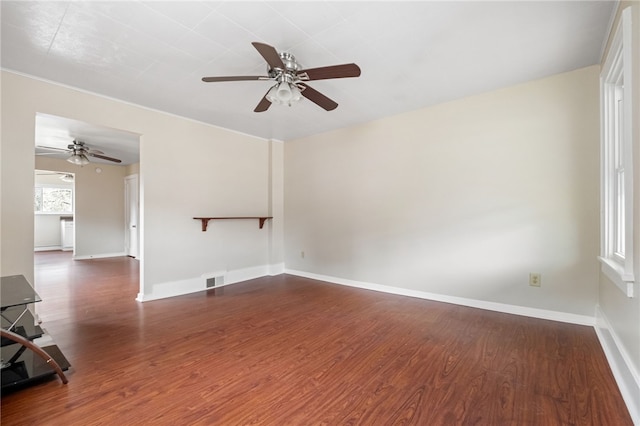 unfurnished room featuring a ceiling fan, visible vents, baseboards, and wood finished floors