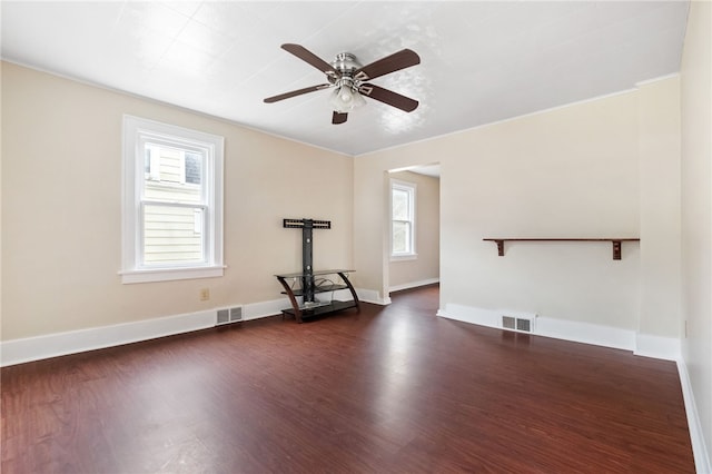 spare room featuring dark wood-type flooring, visible vents, and baseboards