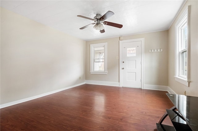 interior space with dark wood-style floors, baseboards, and a ceiling fan