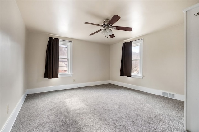 unfurnished room with plenty of natural light, carpet, and visible vents