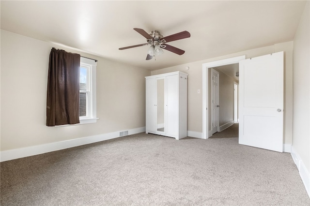 unfurnished bedroom with a ceiling fan, carpet, visible vents, and baseboards