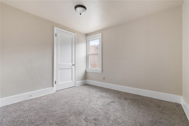 spare room featuring carpet flooring and baseboards