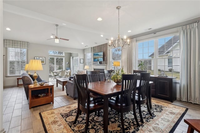 dining space with ceiling fan with notable chandelier, light wood-style flooring, recessed lighting, and a healthy amount of sunlight