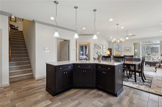 kitchen featuring light wood finished floors, open floor plan, recessed lighting, and dark cabinets