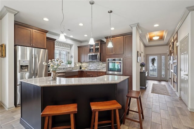 kitchen featuring tasteful backsplash, stainless steel appliances, crown molding, and light stone counters