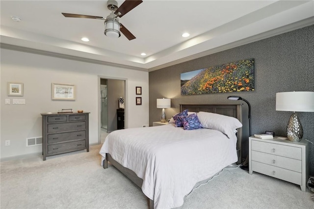 carpeted bedroom featuring visible vents, an accent wall, ceiling fan, recessed lighting, and a raised ceiling