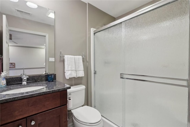 bathroom featuring visible vents, vanity, toilet, and a shower stall