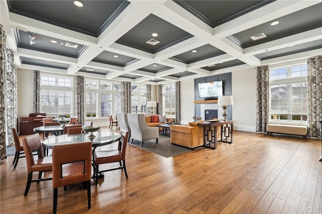 dining area with visible vents, beamed ceiling, wood finished floors, and a fireplace