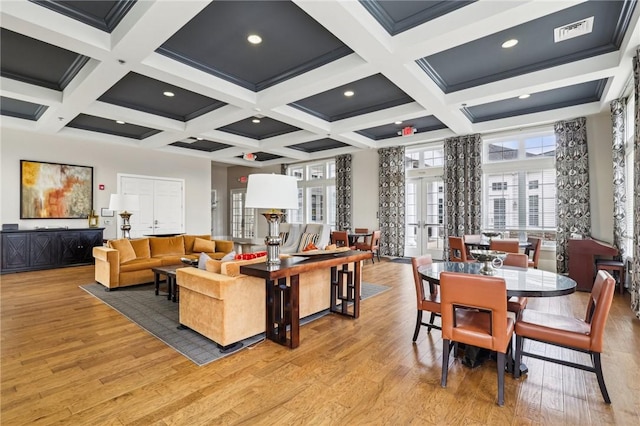 interior space with light wood-type flooring, french doors, beam ceiling, and visible vents