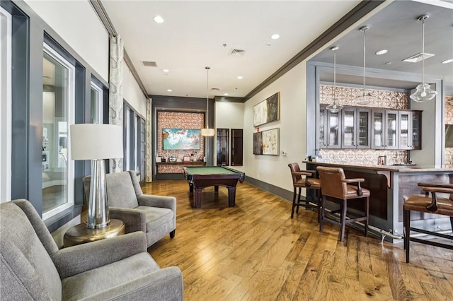 playroom featuring billiards, wood finished floors, baseboards, indoor wet bar, and crown molding